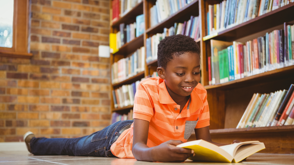 boy reading a book on the floor