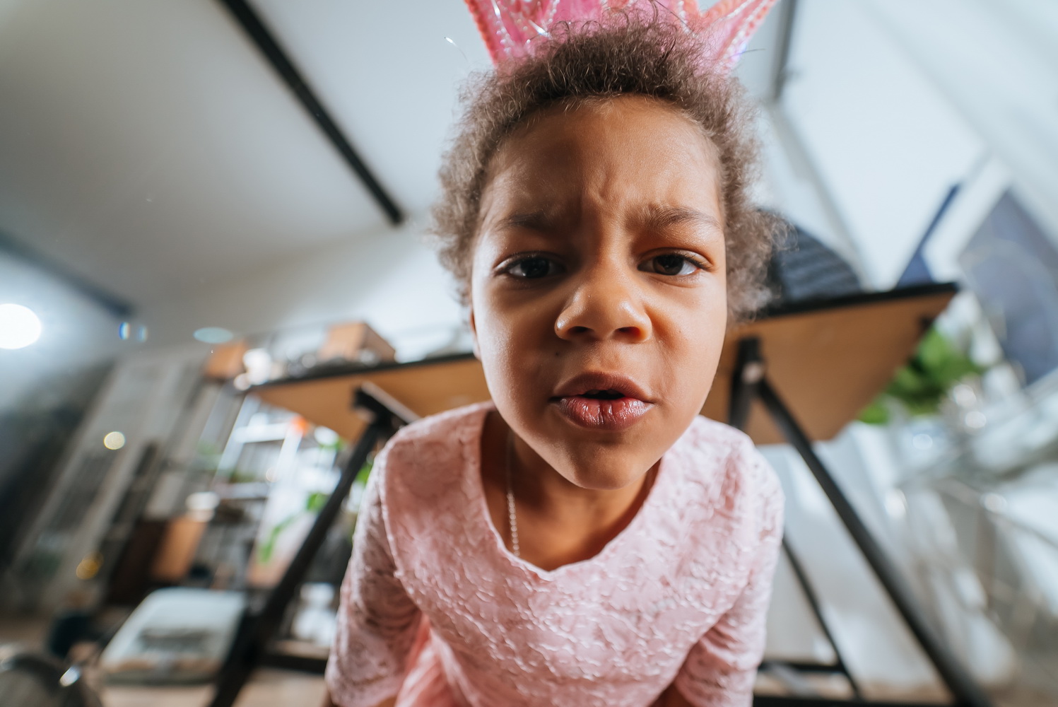 little girl sitting on the floor grimacing