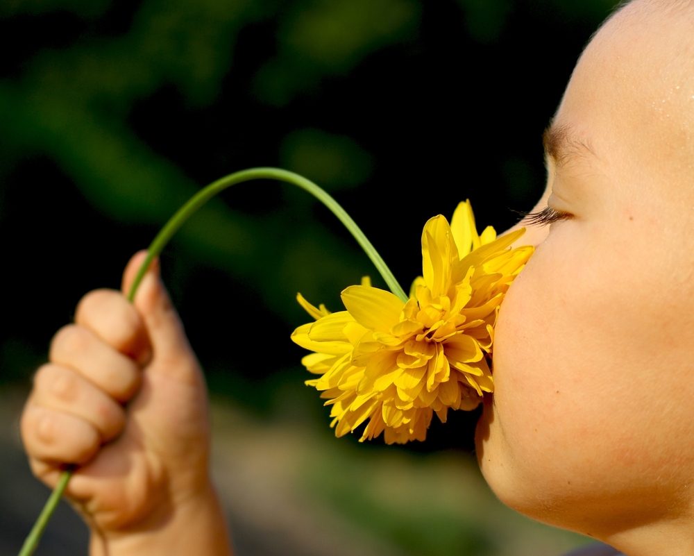 girl is smelling a flower
