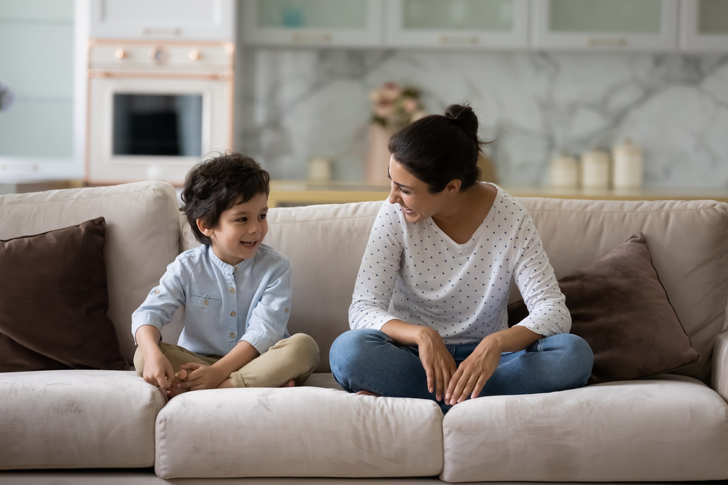 photo of mother and child talking on a sofa