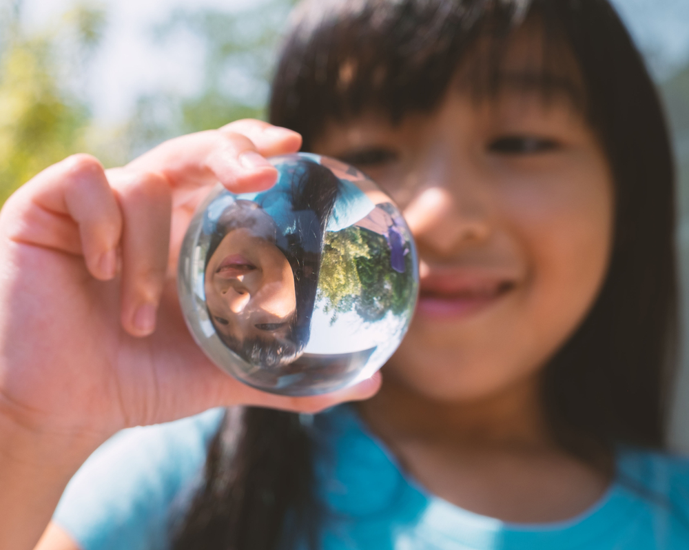 girl looking at a glass ball