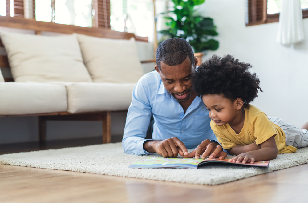 father reading a book to his little son