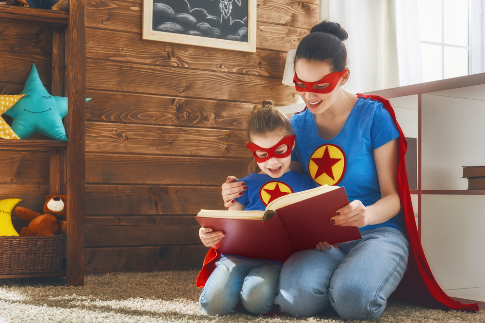 mom is reading a book to her daughter