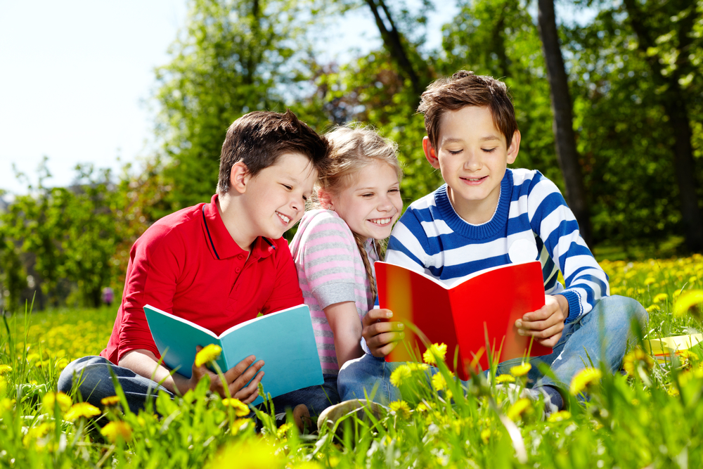 Children reading outdoors.