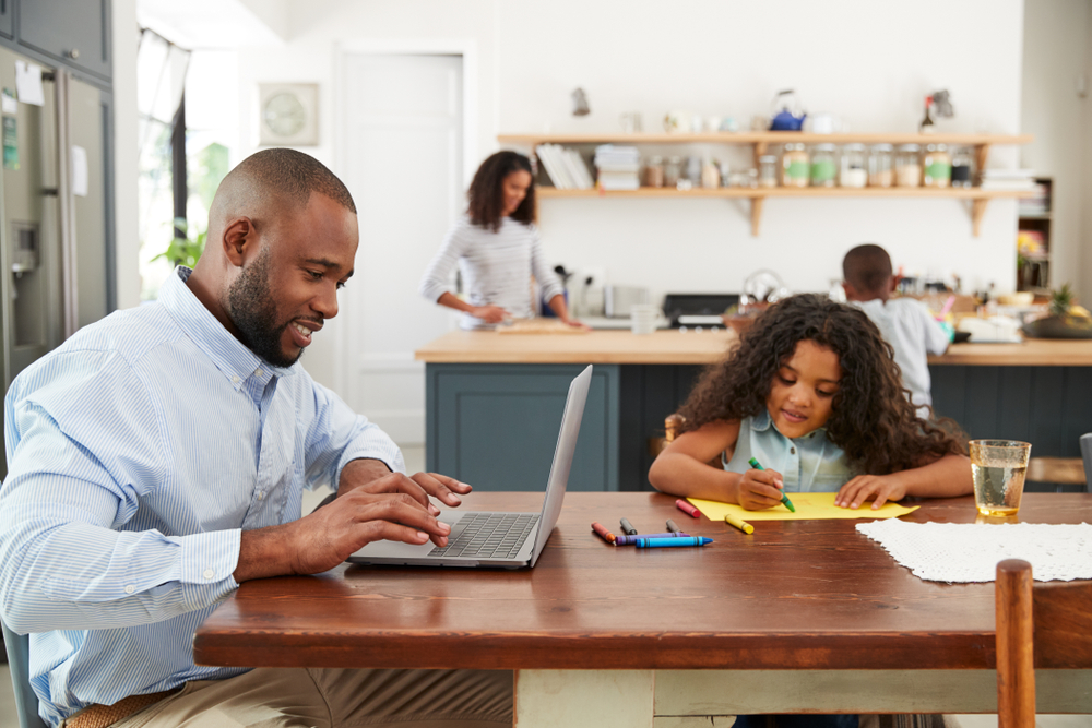 father is sitting at the desk with daughter