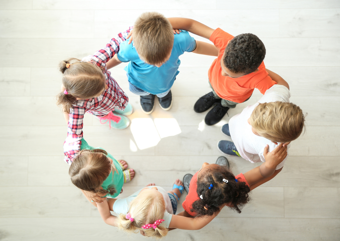 children holding shoulders each other in a round