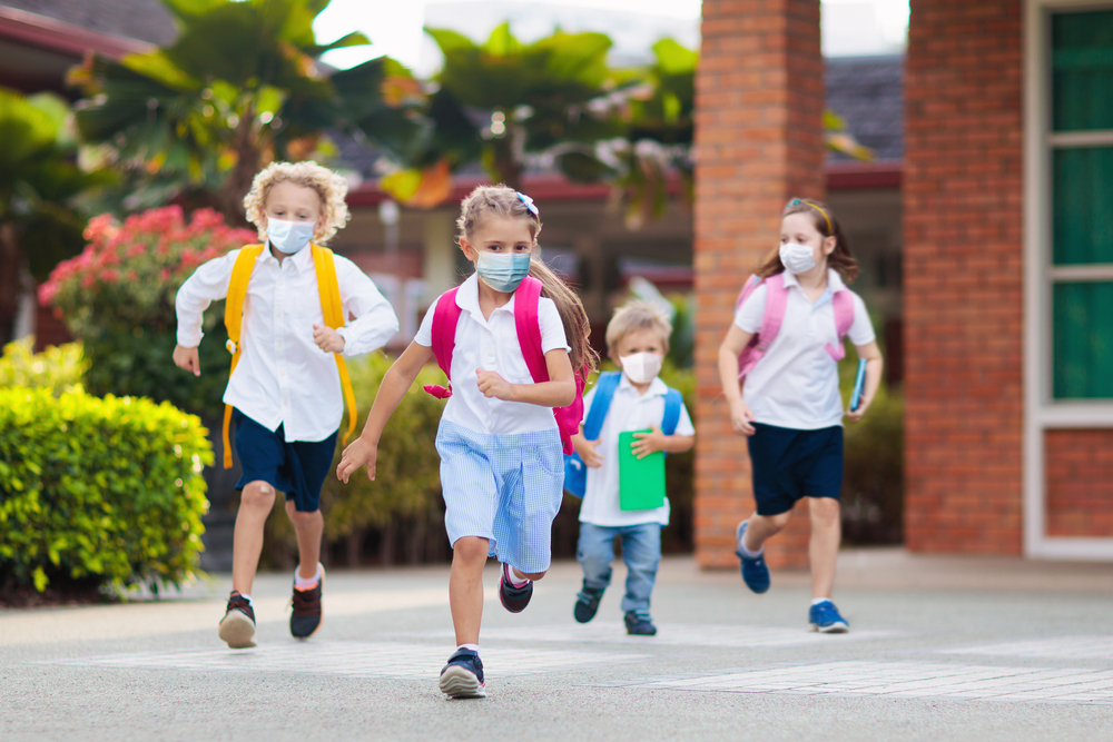 children running to school in masks