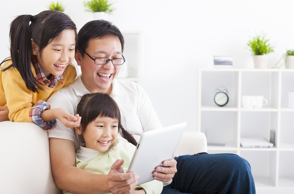 a father with daughters looking at ipad