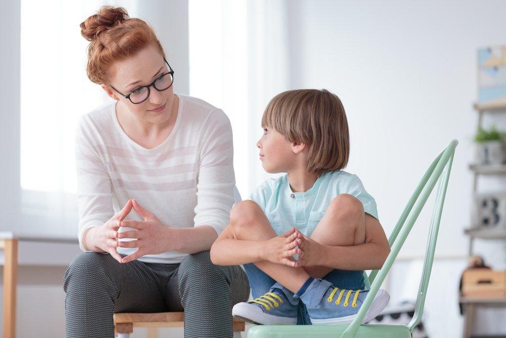 a kid talking to a teacher