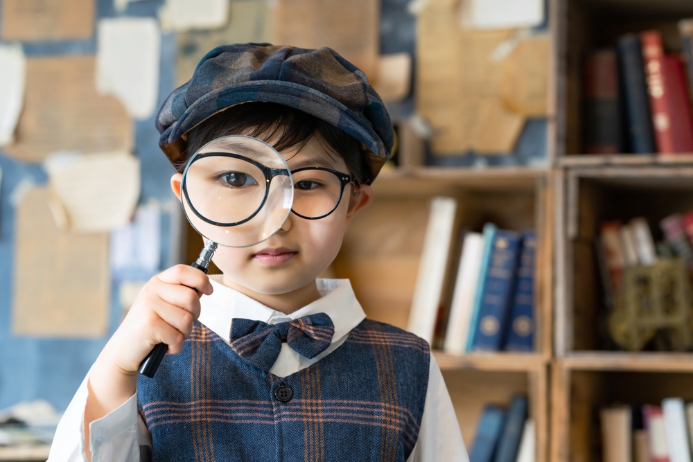 Asian child with a magnifying glass